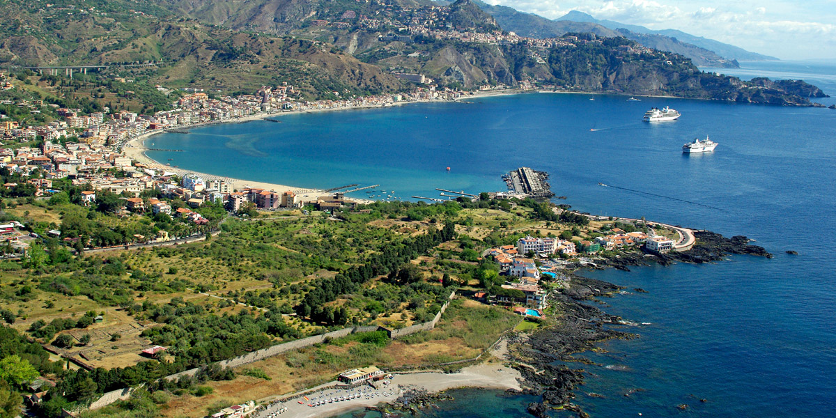 Die spitz auslaufende Landzunge in Lavagestein von Schisò in der Nähe des Hafens von Giardini-Naxos und Bucht von Taormina. Autor: fotovideomike (bearbeitet)